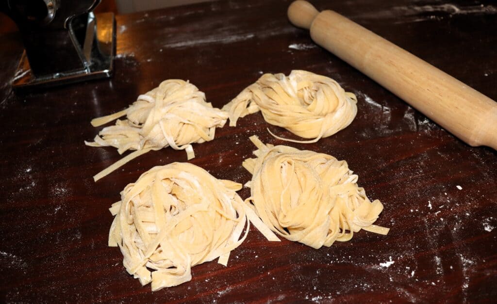 pasta nests on table with rolling pin