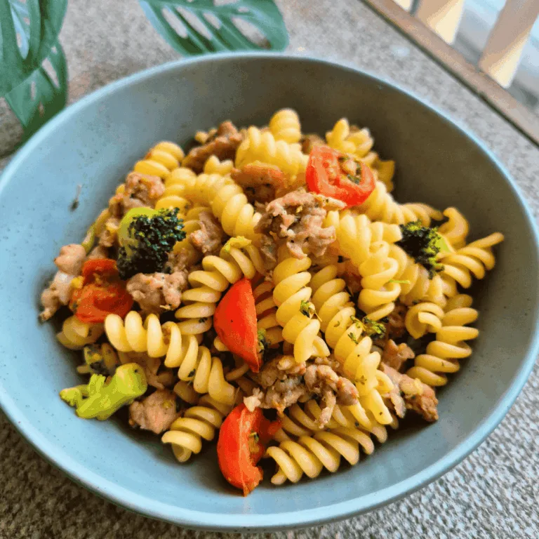 Tomato, Broccoli & Pork Pasta in green bowl