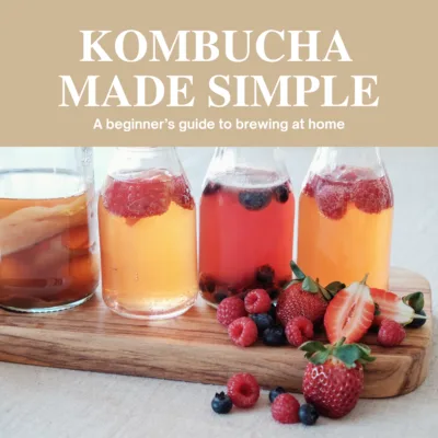 fizzy drink in glass jars siting on wooden platter with berries